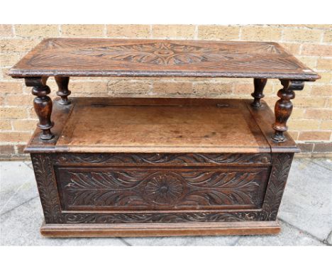 AN OAK MONKS BENCH WITH CARVED DECORATION  107cm wide, 46cm deep, 97cm high as a bench, 79cm folded down as a table