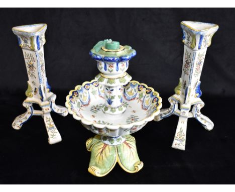 A FAIENCE CANDLESTICK WITH LARGE DRIP TRAY  23cm high, and two matching faience candlesticks with polychrome enamelled floral