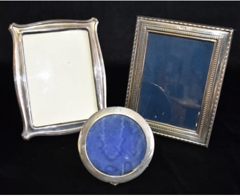 THREE SILVER PHOTO FRAMES  Comprising a rectangular with blue felt backing and easel stand 22cm x 18 cm, one with curved side