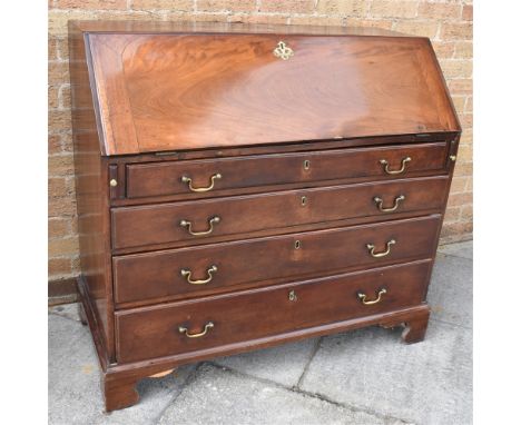 19TH CENTURY OAK BUREAU the fall front opening to reveal a central cupboard, with two pigeon holes above a single drawer, and