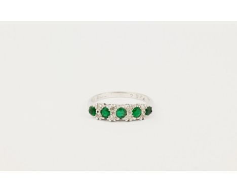 An 18ct white gold, emerald and diamond half hoop, featuring 5 round cut emeralds with chip diamond accents, ring size K 