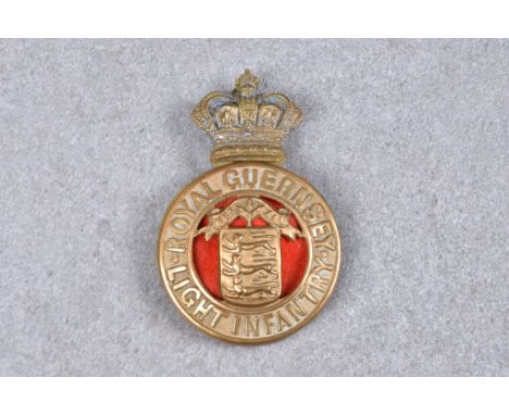 A Royal Guernsey Light Infantry cap badge / helmet plate, Guernsey Arms encompassed by belt reading 'Royal Guernsey Light inf