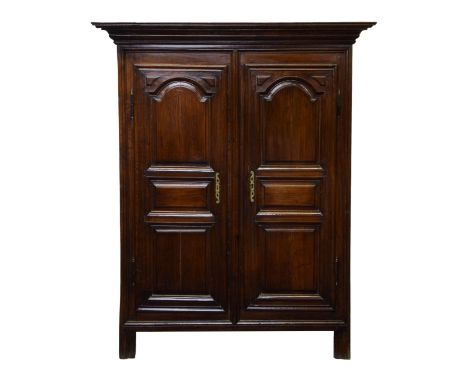 the flared, moulded cornice over five panel sides and a pair of three panel doors with pierced brass escutcheons and exposed 