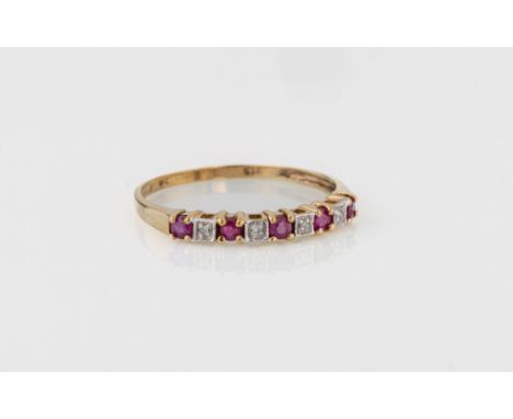 A 9ct yellow gold, ruby and diamond nine stone ring, with round cut rubies spaced with single cut diamonds, size R½.. 