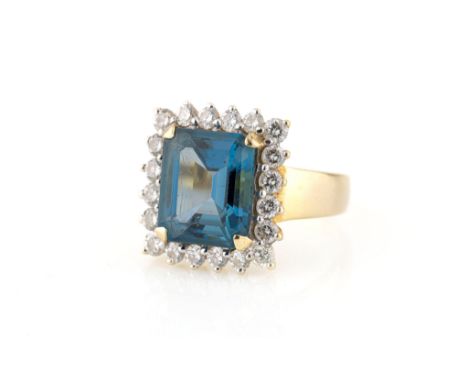 An 18ct yellow gold, emerald cut topaz and diamond cluster ring, the 12 x 10mm. blue topaz within a cluster of twenty brillia