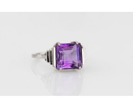 A mid-century Art Deco style 9ct white and gold and amethyst ring, the 9.5 x 9.5mm. square cut amethyst over step cut shoulde