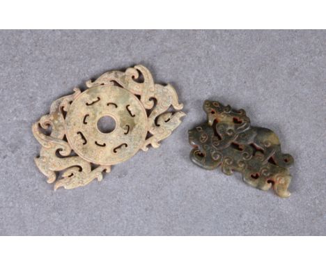 A Chinese celadon jade reticulated dragon disc, in the Song style, extensively calcified and with pale brown inclusions, 4¼in