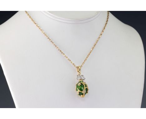 A 18ct two-colour gold, enamel and diamond egg pendant, the green enamel egg wrapped in yellow gold branches with enamel and 