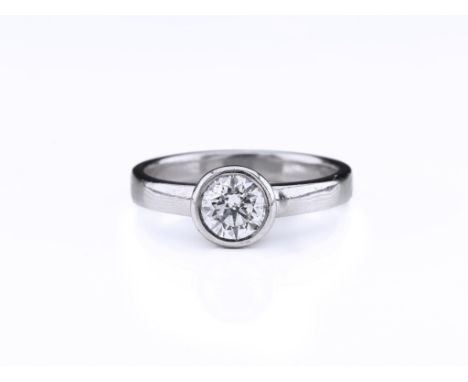 A platinum and diamond solitaire, the brilliant-cut diamond held in a platinum bezel-setting, diamond totalling 0.70ct, ring 