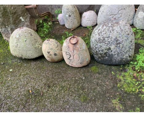 Four granite weights, one inscribed “20” with iron ring, 8½in. (21.6cm.) high; one possibly engraved “13”, 7in. (17.8cm.) hig