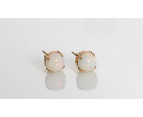 A pair of 9ct gold and opal stud earrings, the 7mm. round cabochon earrings in four claw settings. (2). 