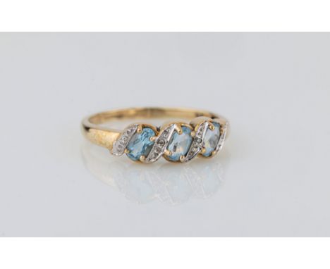 A 9ct yellow gold, aquamarine and diamond ring, the three oval cut aquamarines divided by diamond set scrolls, size R½.. 