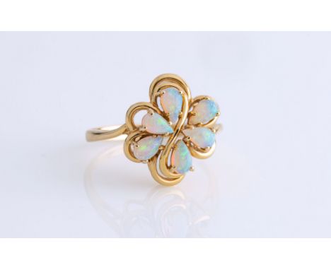 A 14ct yellow gold and opal ring, set with six pear shaped cabochon opals in an openwork floral cluster, ring size K.. 