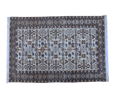 A 20th century Bokhara style rug, the brick red ground with three rows of fifteen Guls, within repeating guards and flag main