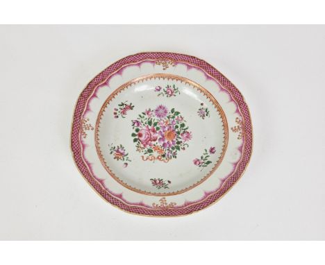 A Chinese porcelain famille rose shallow dish / soup plate, 19th century, with floral decoration to the well and puce fish-sc