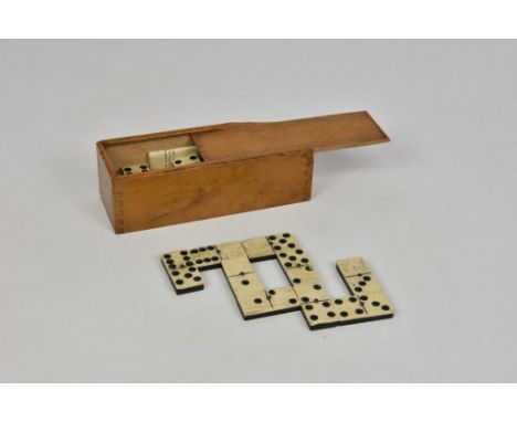 An early 20th century boxed complete 28 piece domino set, bone and ebony, with its original ‘Rules of Dominoes’ booklet, box 
