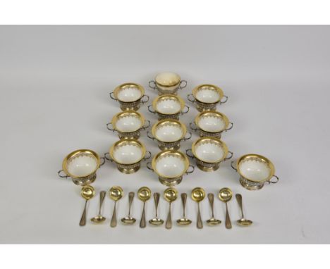 A boxed set of twelve Dresden cobalt blue and gilded small bowls, with pierced silver, two-handled holders and silver gilt sp