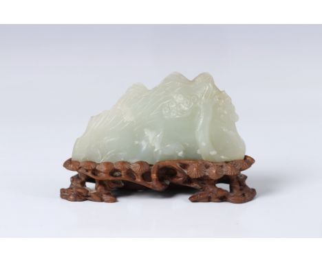 A Chinese jade mountain carving, probably Qing Dynasty, 18th century, in celadon jade with white mottled inclusions, depictin