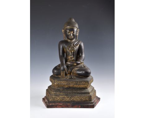 A 19th century Burmese Mandalay dry lacquer seated figure of Buddha, seated in dhyanasana on a tiered, hexagonal base, decora