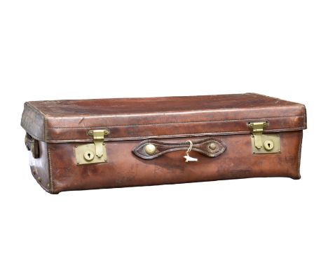 An antique dark tan leather suitcase, the heavy leather case with brass fittings, the interior with light tan pigskin lining,