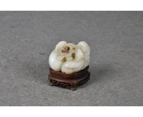 A Chinese pale grey and dark brown jade group of three kid goats, probably Qing dynasty, the three goats sharing a meal of ru