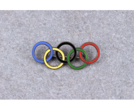 A Berlin 1936 Summer Olympic Games visitors badge, in the form of the Olympic rings, enamel on white metal, marked ‘CP Ges Ge