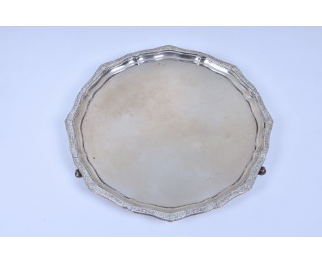 A George VI silver salver, Adie Brothers Ltd, Birmingham, 1950, having shaped stylised cast silver rim, raised on three sroll