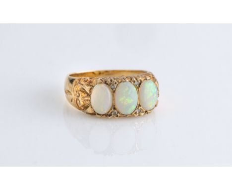 A 9ct yellow gold, opal and diamond Victorian style ring, hallmarked London 1977, the three oval cabochon opals divided by pa