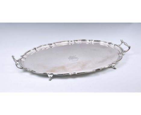 An Edwardian twin handle silver tray, Barker Brothers, Chester 1908, oval form with pie-crust rim, engraved with initial ‘S’ 