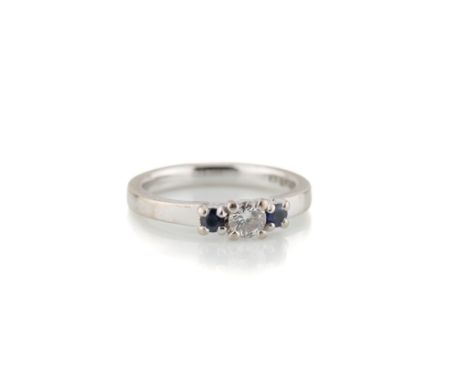 An 18ct white gold, sapphire and diamond three stone ring, the central, approx. 0.2ct brilliant cut diamond, flanked by round