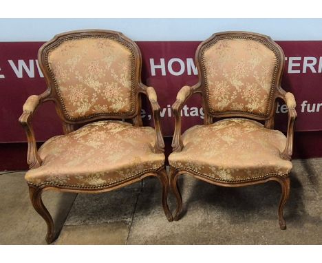 A pair of early 20th Century French Louis XV style carved beech and fabric upholstered fauteuil chairs 