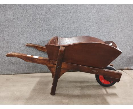 A stained beech wheelbarrow planter 