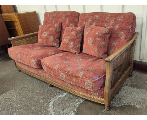 An Ercol ash bergere and fabric upholstered three seater settee 