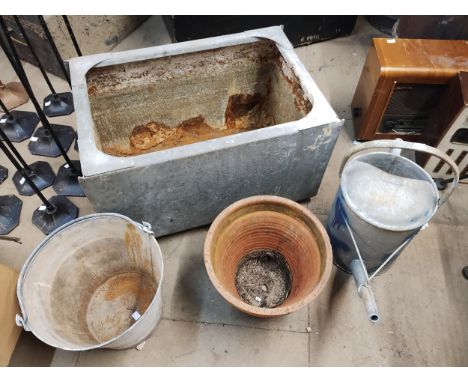 A galvanised watering can, bucket, water tank and a terracotta planter