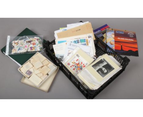 A box of various first day covers, PHQ cards and British and world stamps, mainly loose.