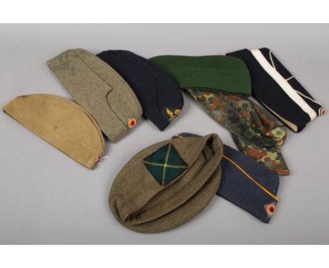 Eight assorted military caps including army, air force and Russian.