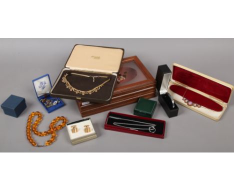 A jewellery box and contents of costume jewellery to include amber coloured beads, cufflinks, yellow metal necklace etc.