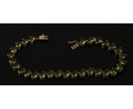 A 9ct gold tennis bracelet set with coloured paste stones, 9.22 grams.
