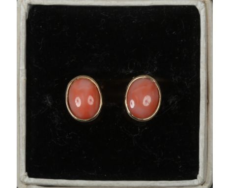 A pair of vintage 9ct gold ear studs each with one ovoid coral stone, having post and butterfly backs.