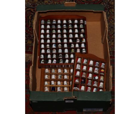 A box of thimbles and wall mounted display cases to include ceramic and metal examples.