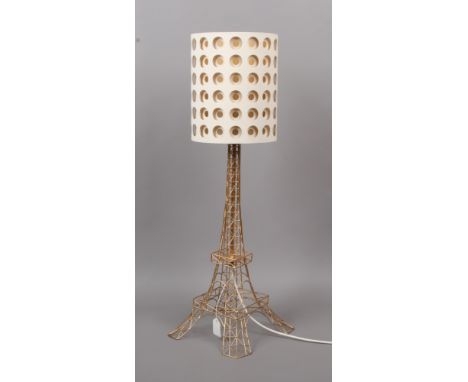 A brass effect table lamp formed as the Eiffel Tower.