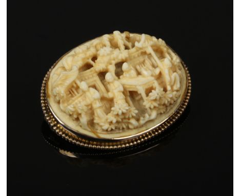 A Victorian gold mounted Cantonese carved ivory ovoid brooch decorated with figures in a village scene, acid tests as 9ct gol