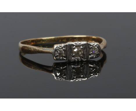 An Art Deco 18ct gold and platinum three stone diamond ring, size O, 1.66 grams.