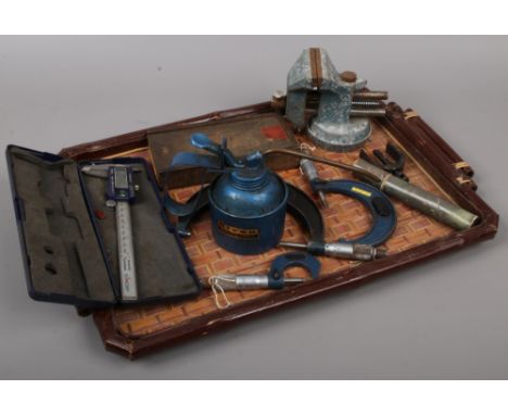 A tray of engineering tools to include vice, oil can, micrometres, caliper etc.