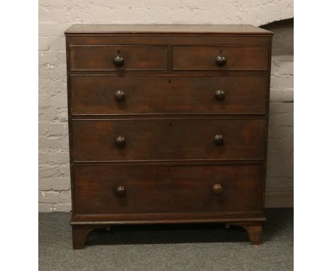 A Victorian oak chest of drawers raised on bracket feet.