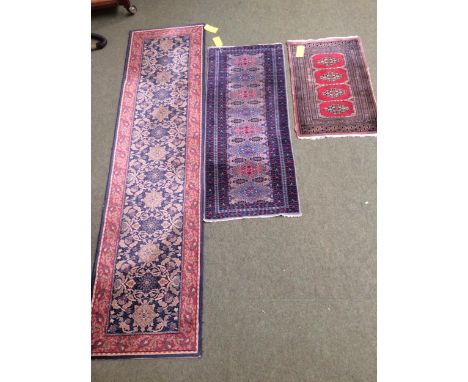 3 rugs:  a runner with red border and blue and floral central panel, and 2 smaller red and blue patterned rugs, with stylized