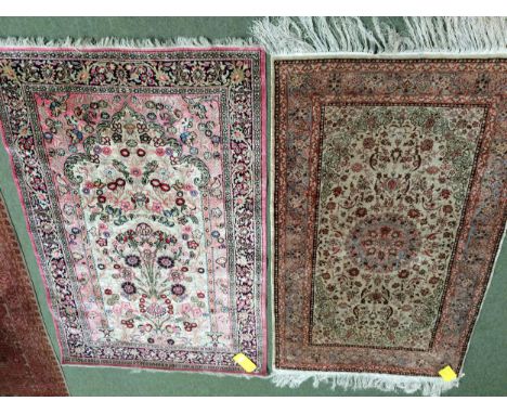 2 silk rugs, 158 x 102cm; 153 x 93cm, one with square green panel ground and red geometric wide borders, and a light coloured