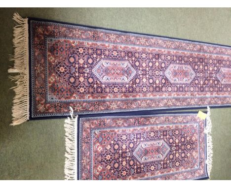 Rugs: Red ground  runner with blue borders and geometric designs, and a similar smaller Runner 269 x 69; 135 x 68cm 