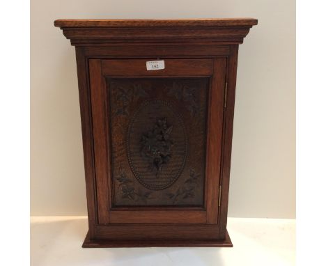 Edwardian hanging wall cabinet with carved front panel, possibly oak, and carved floral rosette to door, 48cmH x 33cmW 