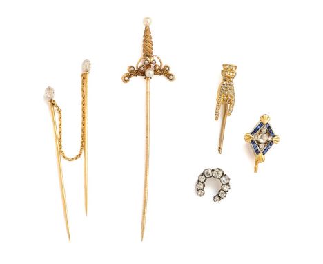 □ COLLECTION OF SIX STICK PINS, 1900s comprising: one designed as a sword with seed pearl hilt, two each surmounted with a br